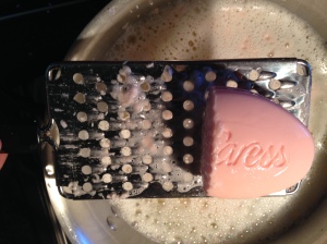 Grate 1/3 of the bar soap into the hot water next.