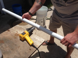 Crab starting to heat the first (practice piece) PVC pipe. He slowly turned it in front of the heat gun (blowing on high) to ensure there was a consistent heat on all sides. Once this is flimsy enough, you can slowly twist it. BE CAREFUL NOT TO DO IT TOO HARD! It will cause a hole. 